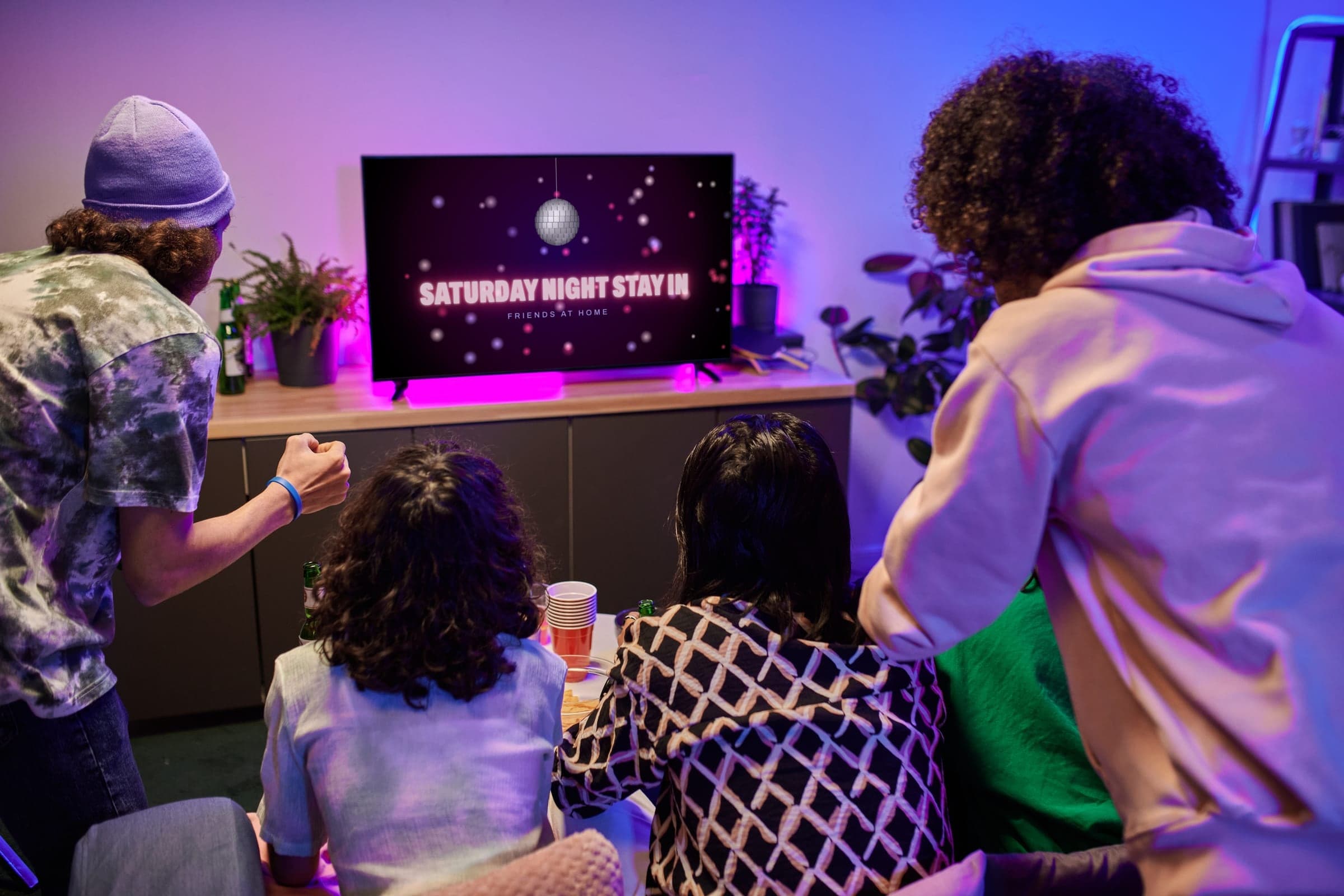Friends cheering at a TV playing a tape's opening