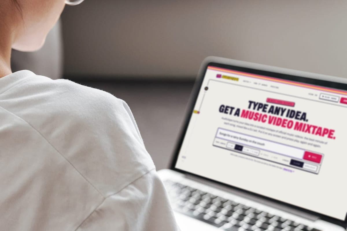Someone on a couch typing an idea into the prompt bar on a laptop